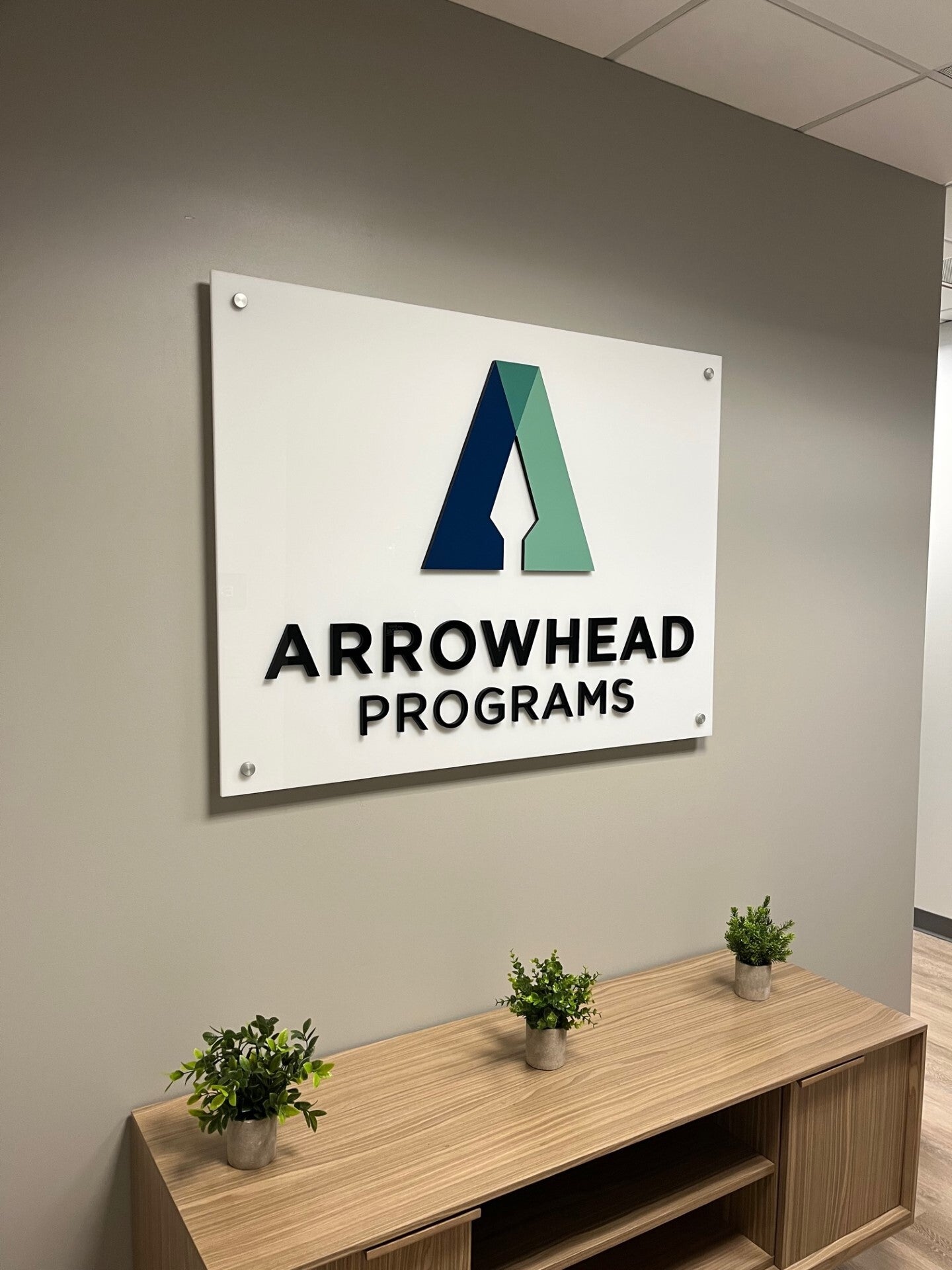 Acrylic lobby wall sign with dimensional logo and lettering for Arrowhead Programs