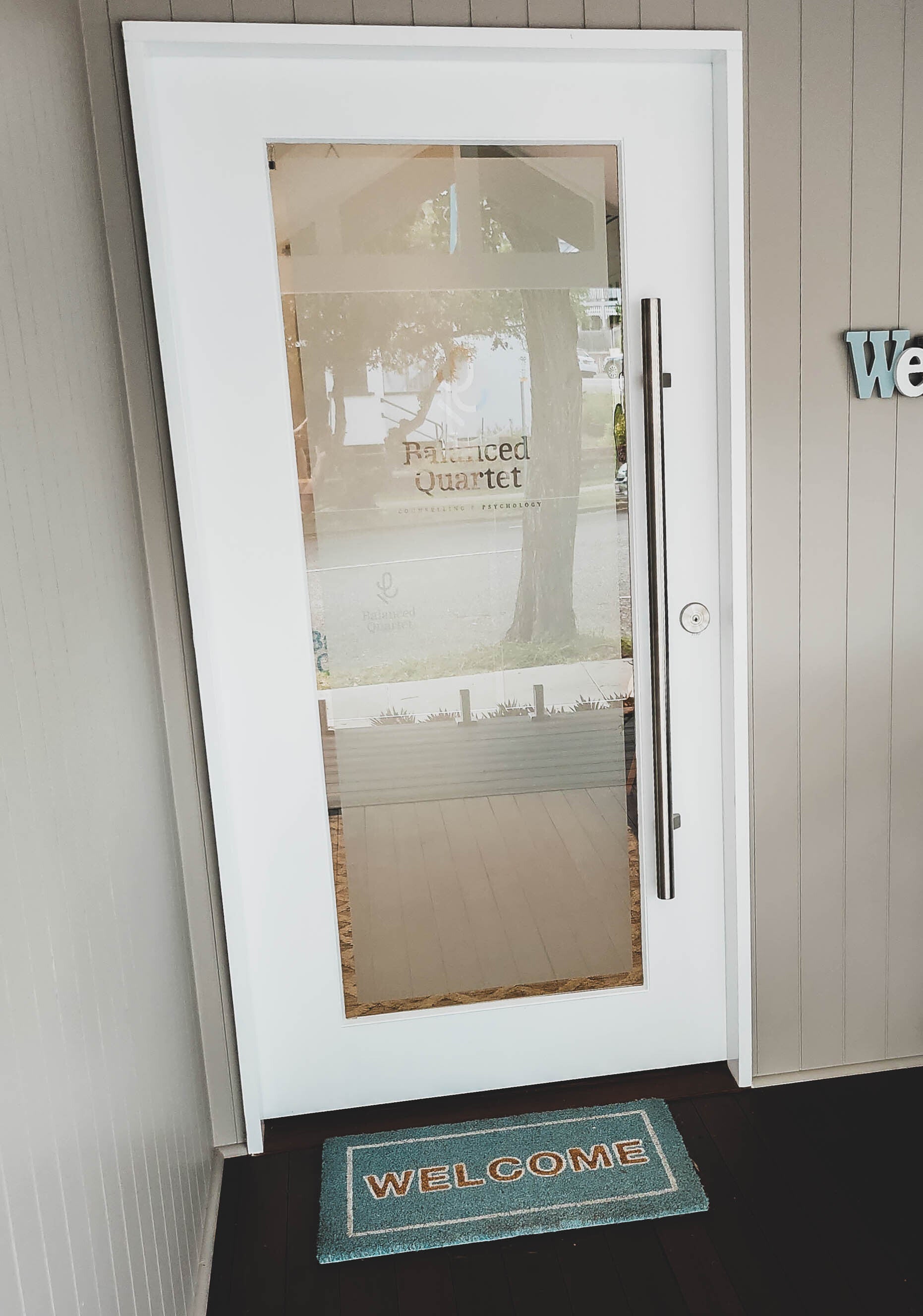 White framed door with frosted glass containing transparent border and lettering for business logo