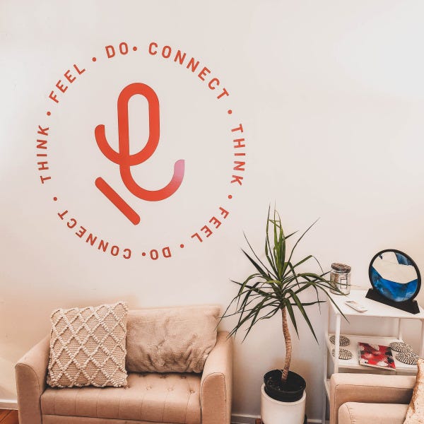 Red coloured wall graphic comprising of lettering in circular shape with company logo in the centre
