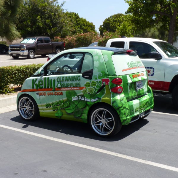 Smart car wrapped with Kelly Cleaning graphics designed by Signarama, promoting cleaning services through vehicle branding