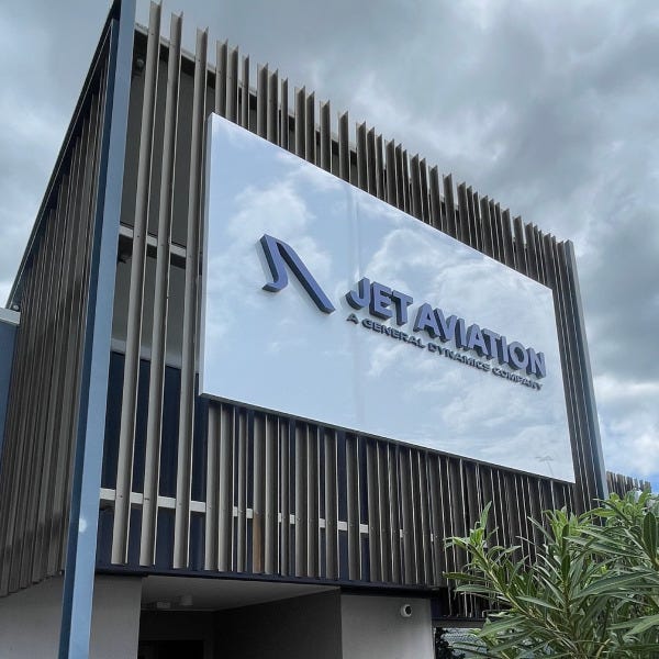 White ACM sign with 3D letters for Jet Aviation installed outdoors against metal slats.