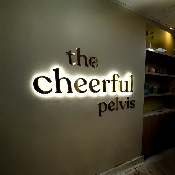 Backlit signage for The Cheerful Pelvis