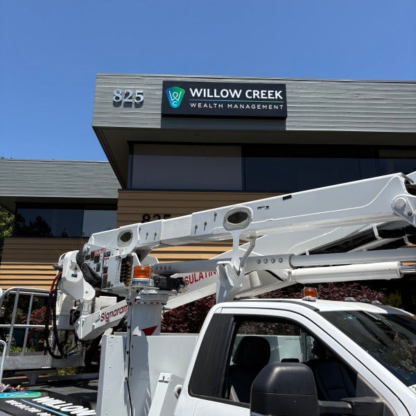 Signarama bucket truck beside a commercial building during sign installation