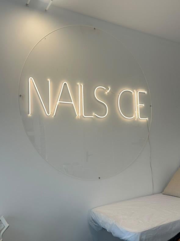 Enseigne  lumineuse avec jolie plaque de plexi ovale. Néon couleur blanc chaud.