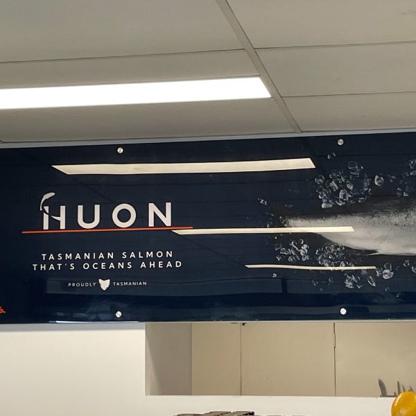 Acrylic signage manufactured by Signarama Brendale for Huon featuring the logo, catchphrase, and an image of a fish against a dark blue background.