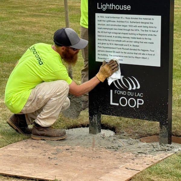 Signarama Employee Cleaning the Loop Sign