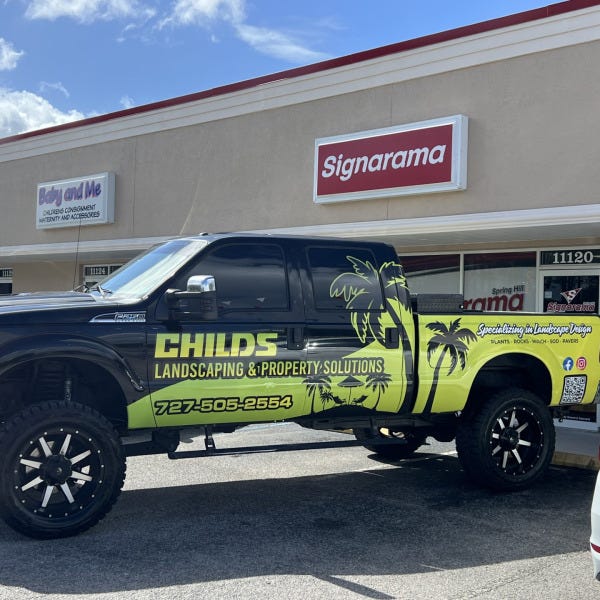 “Custom landscaping company truck wrap with bold green and black graphics installed at Signarama Spring Hill, showcasing professional vehicle branding.”