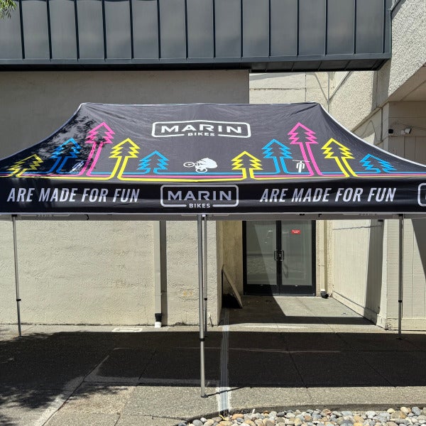 Black Marin Bikes canopy with colorful cycling graphics set up outdoors