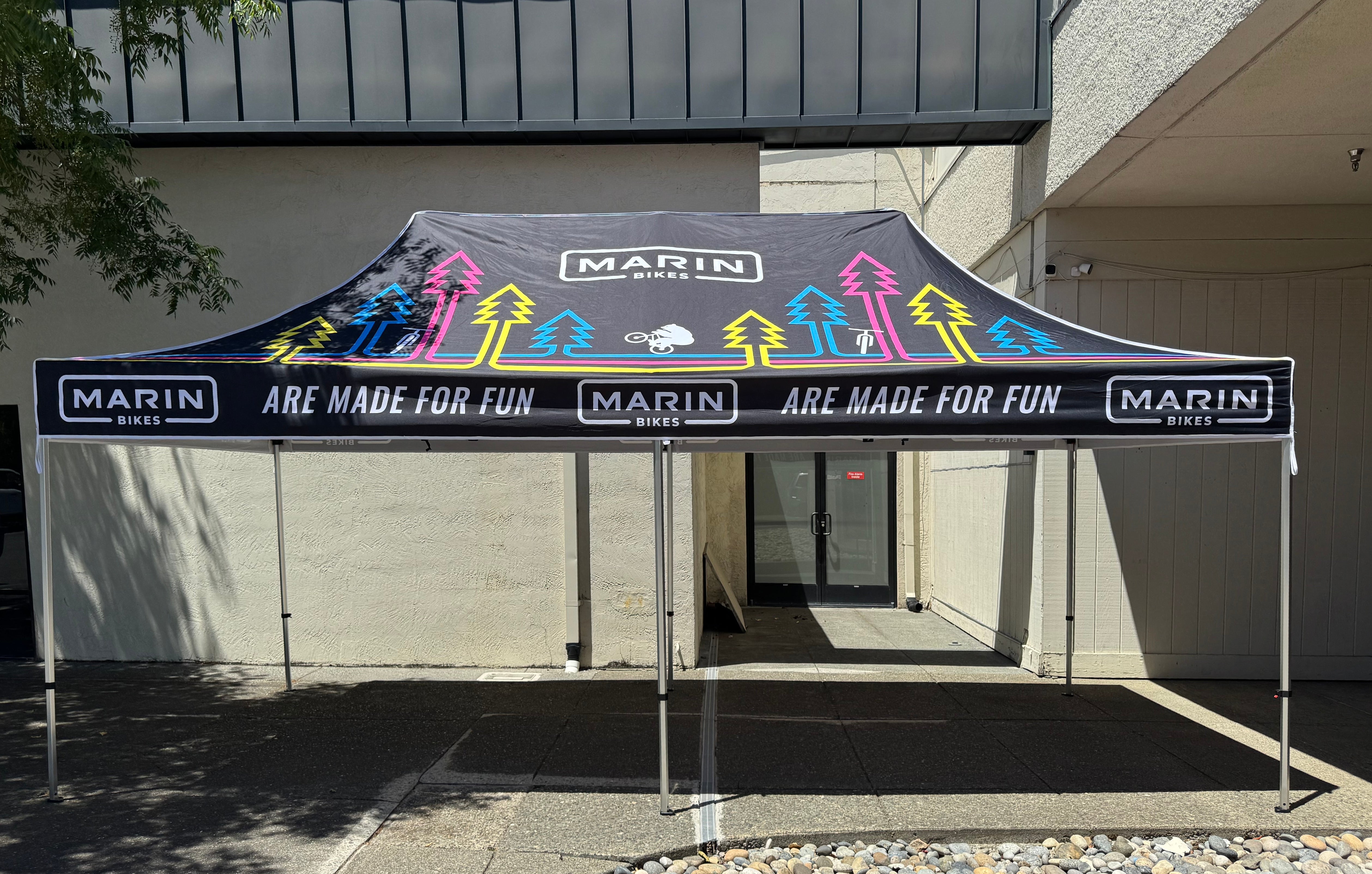 Black Marin Bikes canopy with colorful cycling graphics set up outdoors
