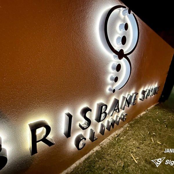 Halo-lit stainless steel letters and 2-Pak sprayed logo installed by Signarama for Brisbane Spine Clinic.