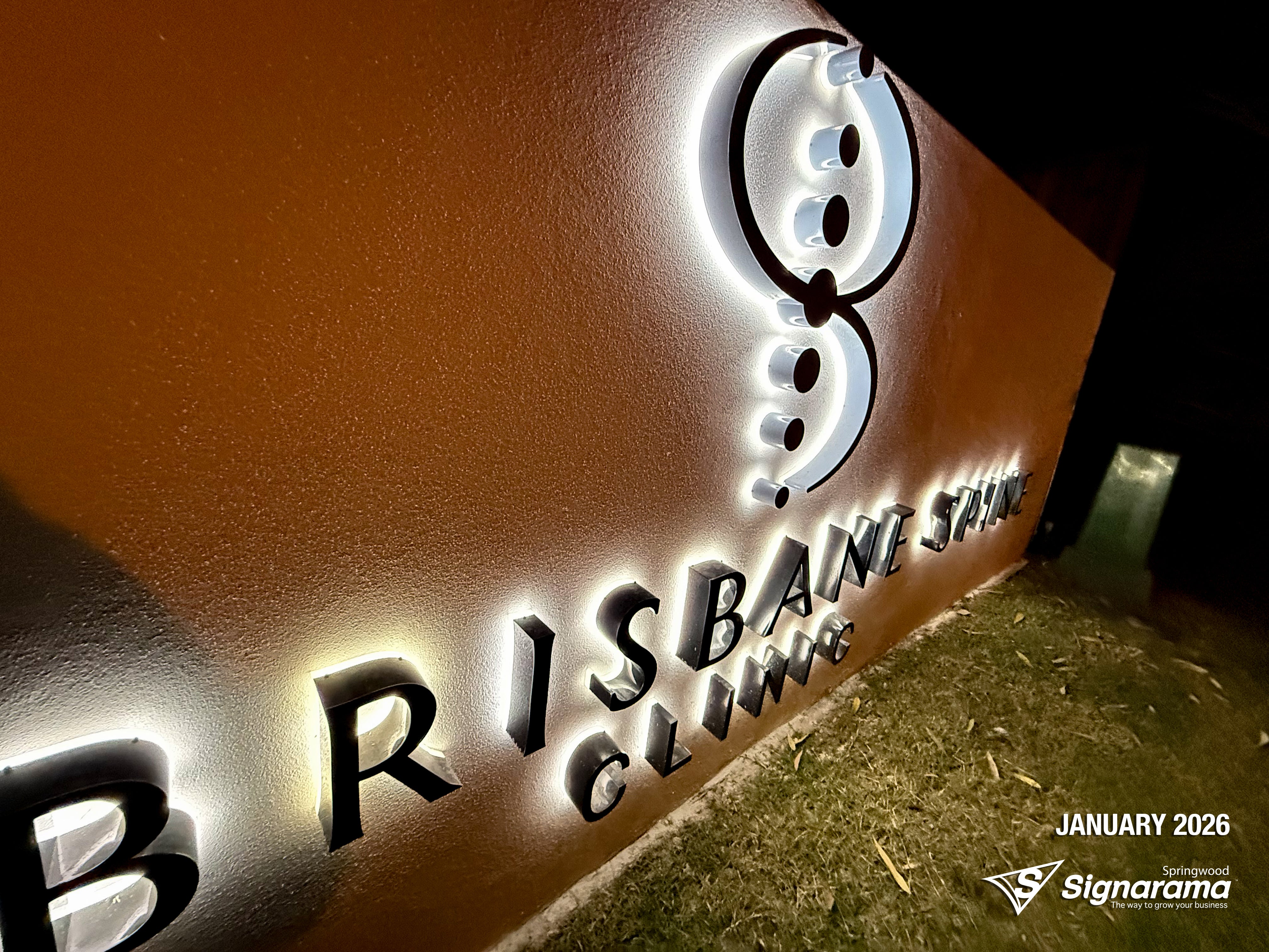Halo-lit stainless steel letters and 2-Pak sprayed logo installed by Signarama for Brisbane Spine Clinic.