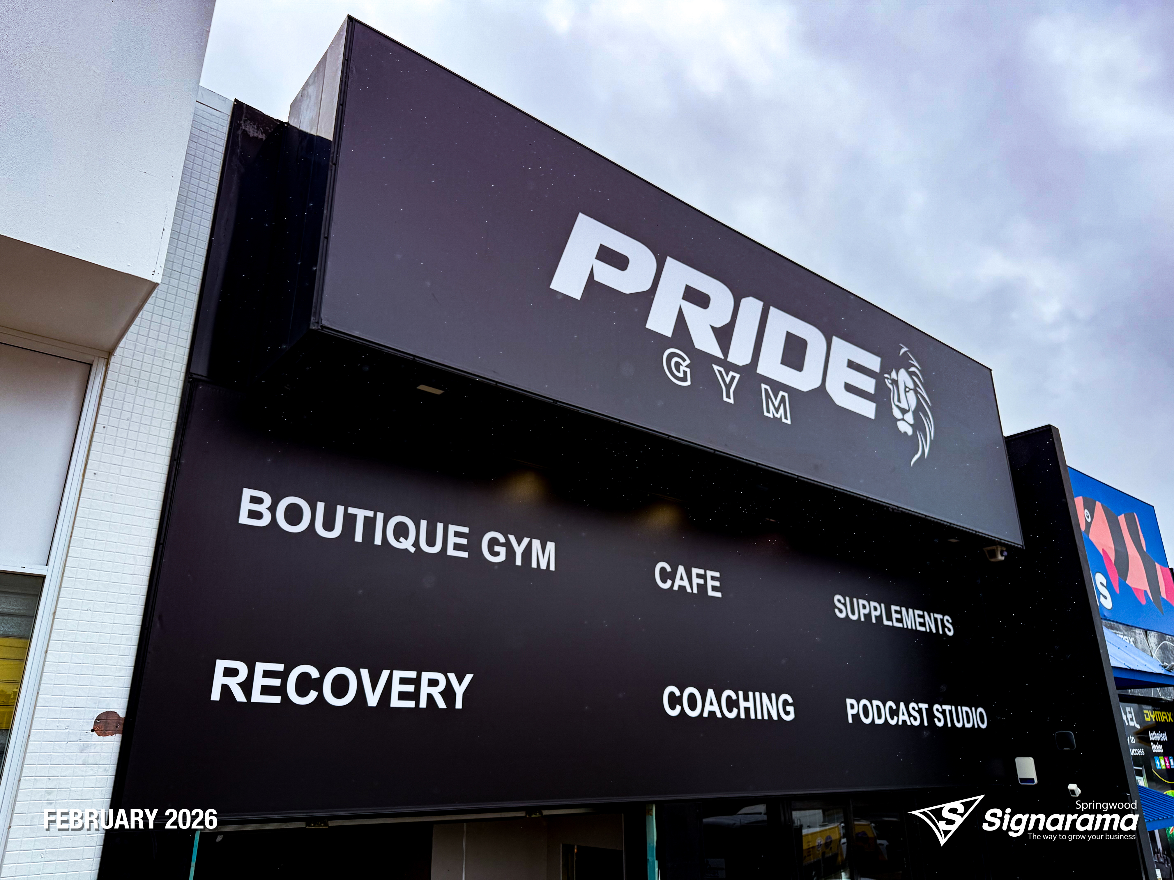 Large storefront sail track banners installed at Pride Gym by Signarama Springwood, featuring bold, high-impact graphics stretched tightly across the building façade to create stro...