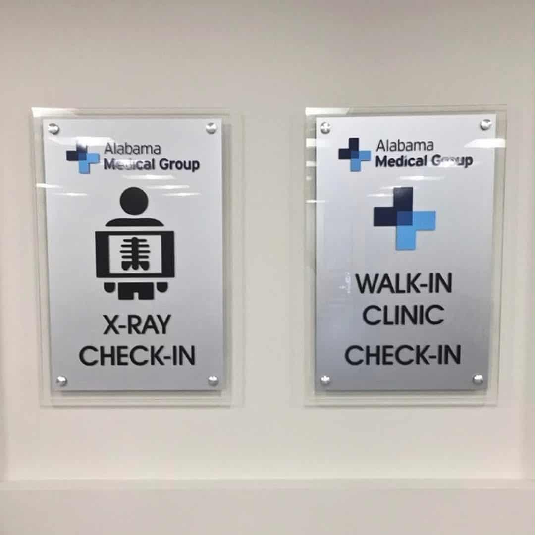 Professionally installed ADA-compliant signage for a medical group, featuring high-contrast "X-Ray Check-In" and "Walk-In Clinic" signs with clear pictograms and non-glare acrylic finishes.