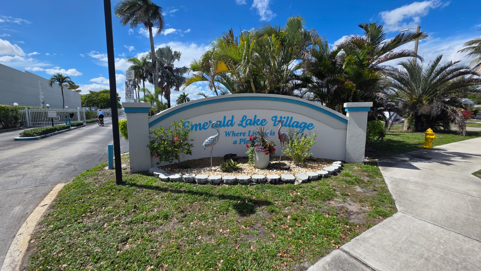 Custom community entrance sign for Emerald Lake Village with decorative landscaping