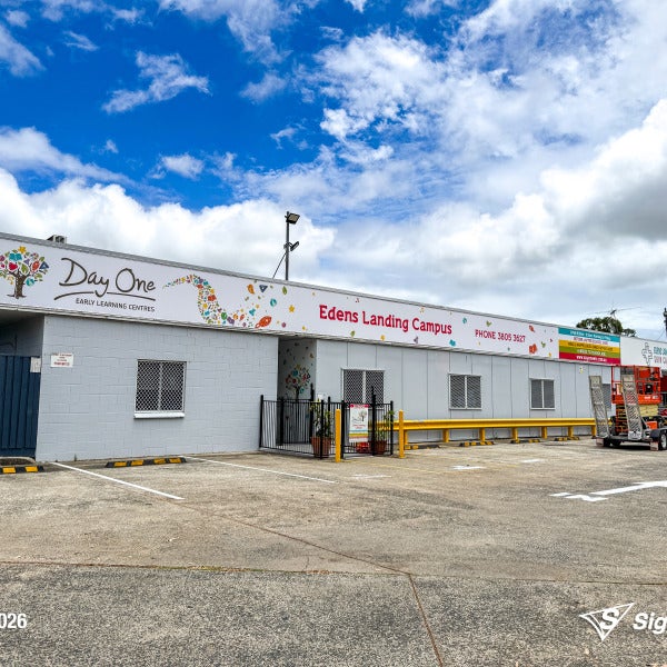 Replaced building signage installed by Signarama Springwood for Day One Edens Landing after hail damage, featuring new durable exterior signage on a commercial building in Queensla...
