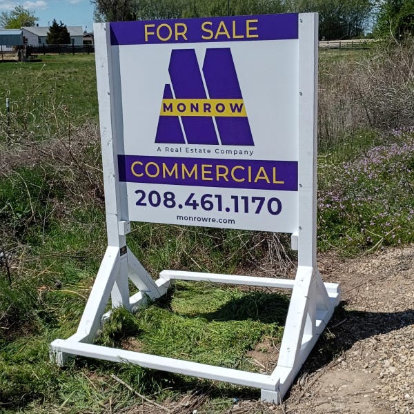 Portable skid-mounted commercial real estate sign on roadside advertising land for sale