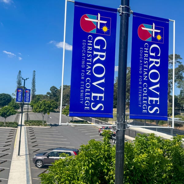 Carpark pole flags installed at Groves Christian College by Signarama Springwood, showcasing tensioned outdoor flags designed for clear visibility and durability