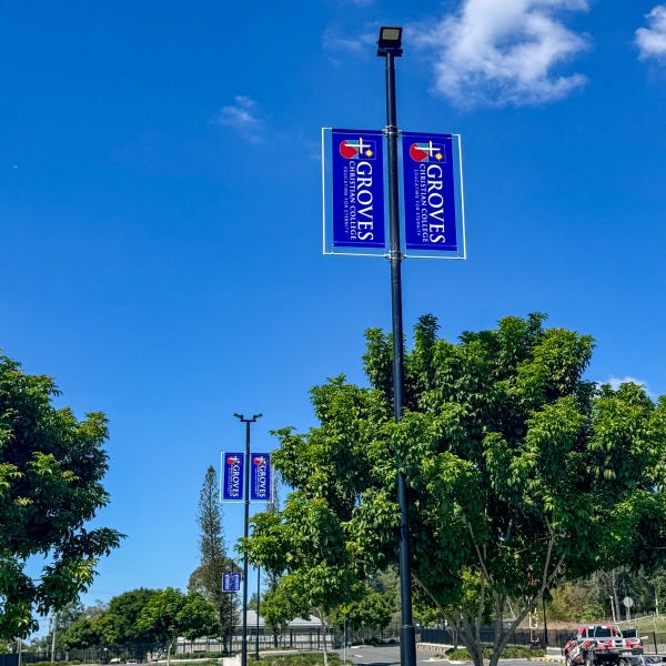 Carpark pole flags installed at Groves Christian College by Signarama Springwood, showcasing tensioned outdoor flags designed for clear visibility and durability
