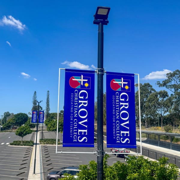 Carpark pole flags installed at Groves Christian College by Signarama Springwood, showcasing tensioned outdoor flags designed for clear visibility and durability