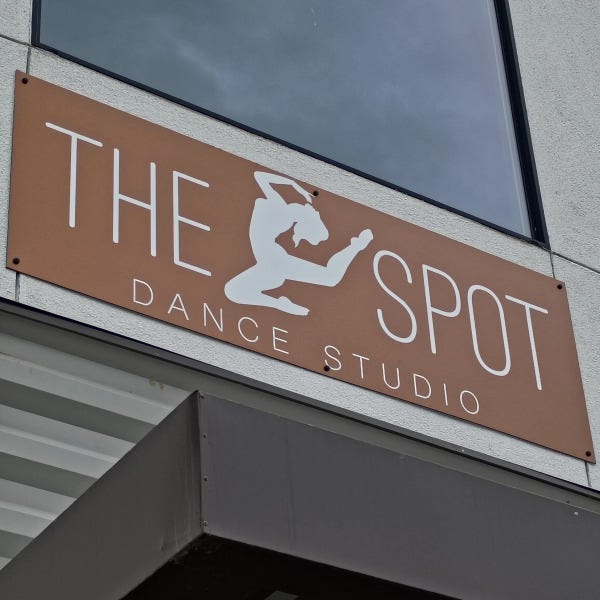 Custom ACM building sign for The Spot Dance Studio with cut vinyl lettering and dancer silhouette