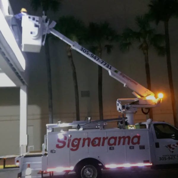 roger installing sign on bucket truck
