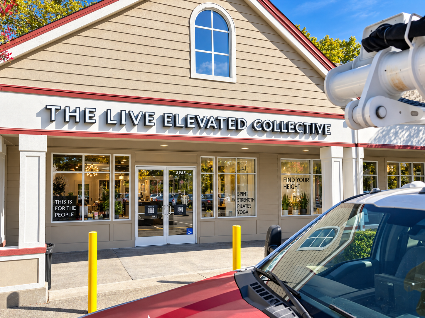 The Live Elevated Collective channel-letter sign above its Windsor storefront, with installation equipment in the foreground.