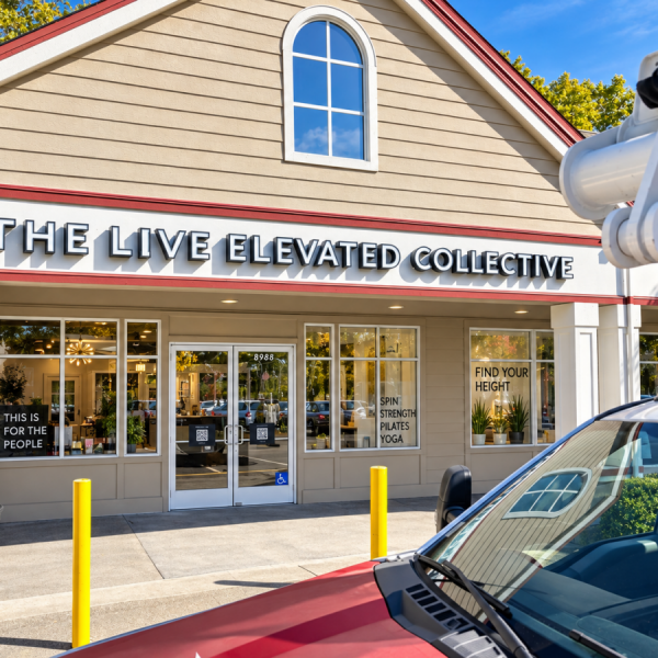 The Live Elevated Collective channel-letter sign above its Windsor storefront, with installation equipment in the foreground.