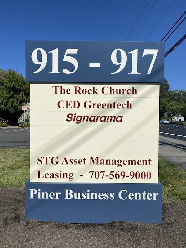 Previous 915–917 Piner Business Center monument with a blue address header and red tenant-name listings