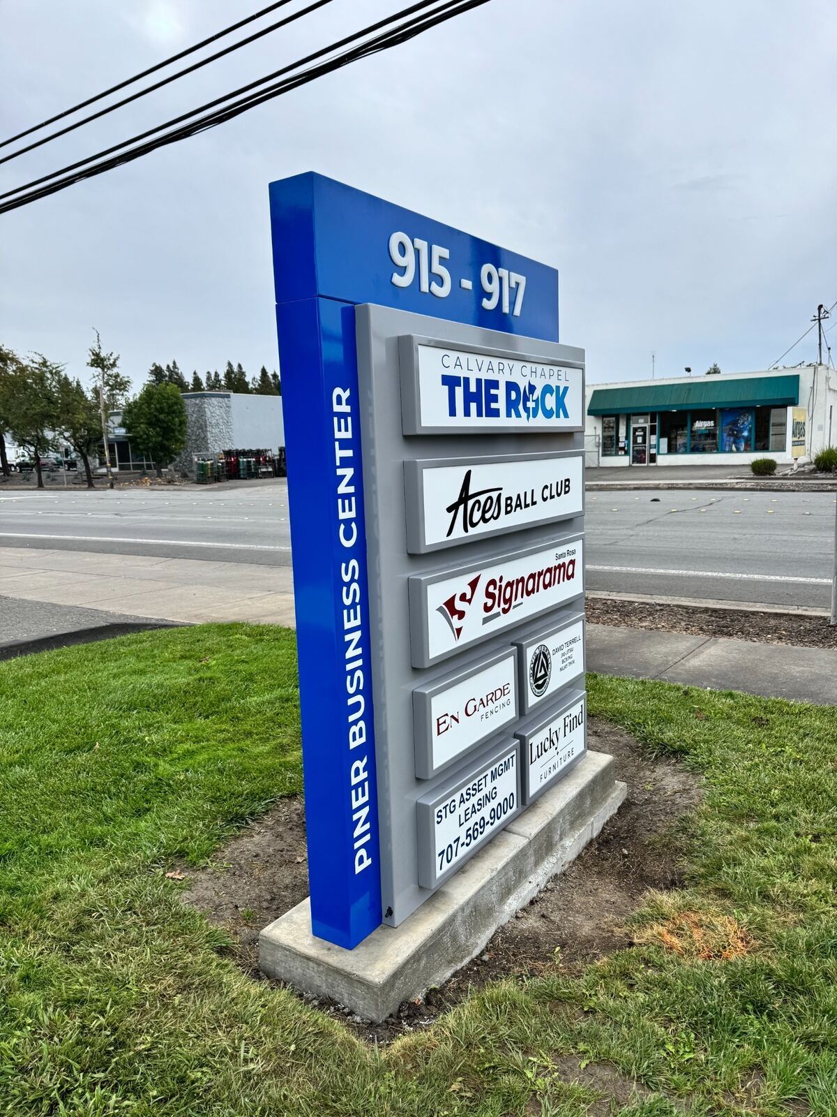 Close angled view of Piner Business Center’s framed tenant panels, dimensional address numbers and vertical property name