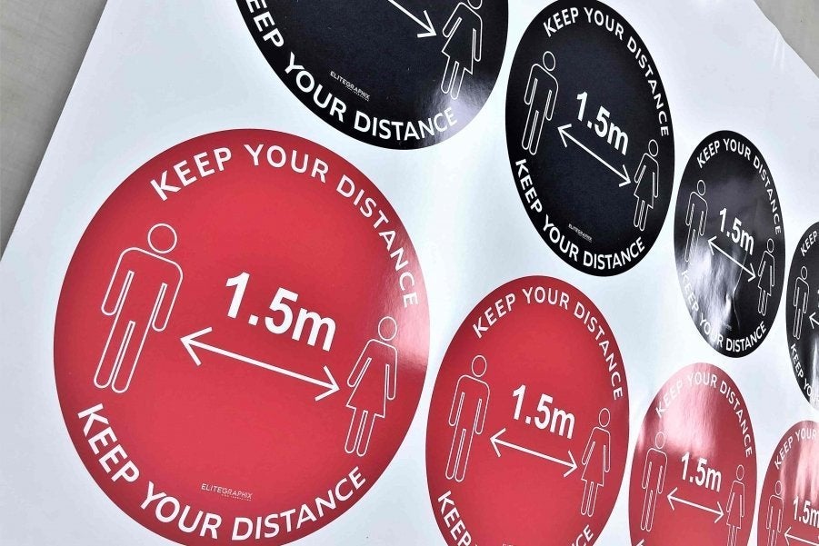 Multiple red and black social distancing floor stickers