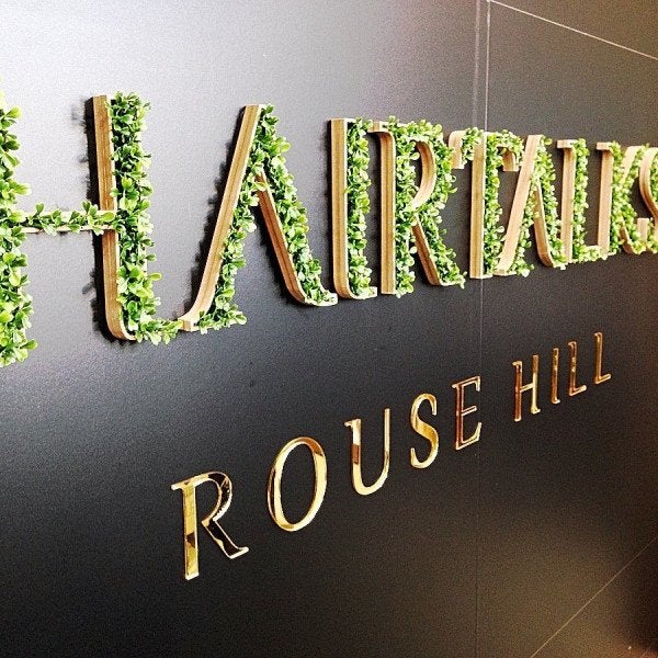 Reception sign for Hairtalks Rouse Hill including fake grass and gold vinyl lettering