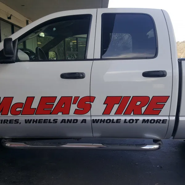 McLea’s Tire logo and lettering on the side door of a white pickup truck