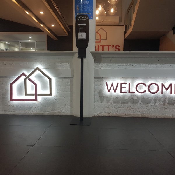 Illuminated 3D Letters on a white brick wall as a business welcome sign