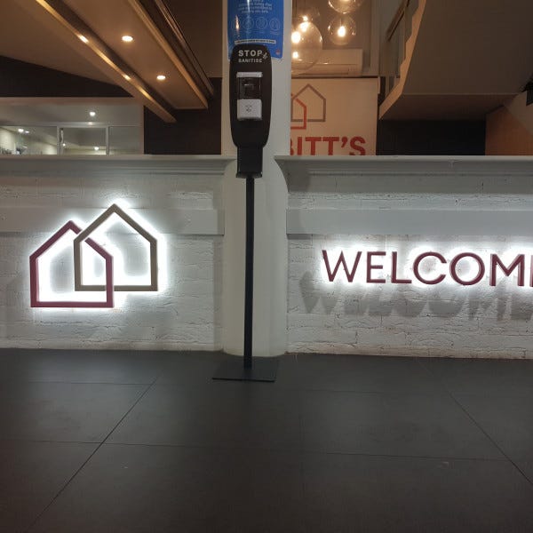Illuminated 3D Letters on a white brick wall as a business welcome sign