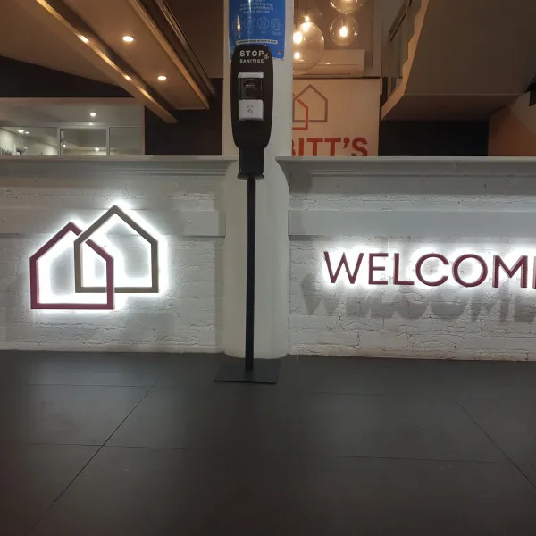 Illuminated 3D Letters on a white brick wall as a business welcome sign