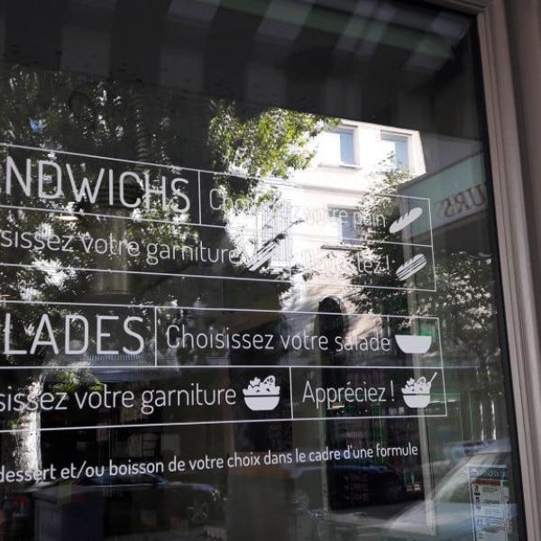 Pose de lettrage adhésif sur la vitrine
