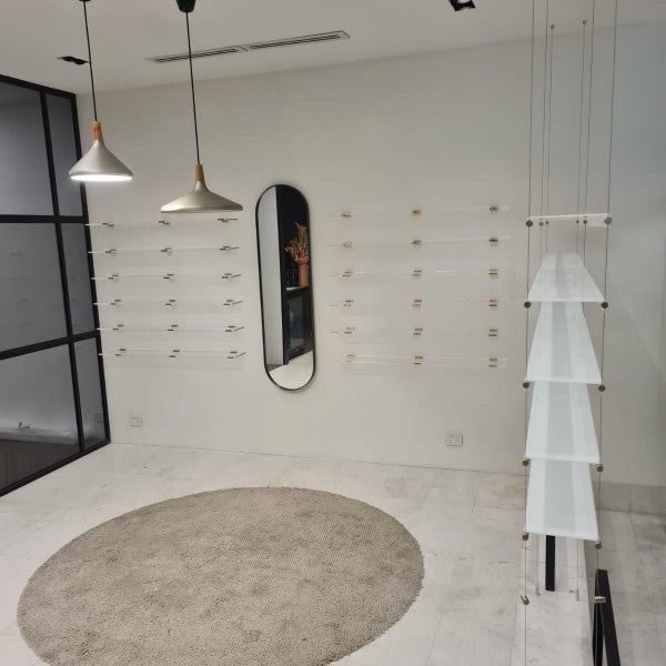 Core Optique Mosman_custom opal acrylic suspension shelf system and custom clear acrylic shelves with gold fixings