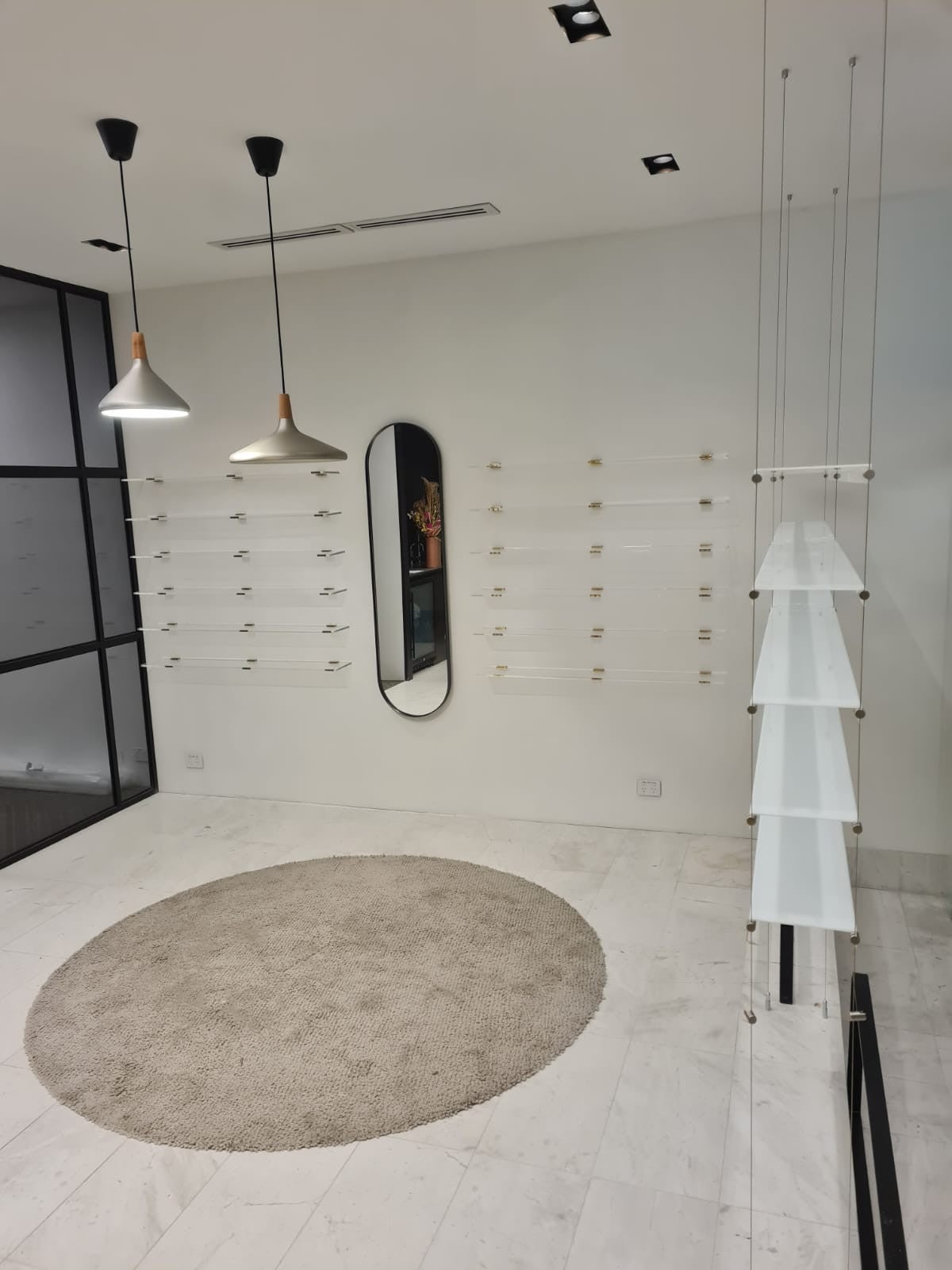 Core Optique Mosman_custom opal acrylic suspension shelf system and custom clear acrylic shelves with gold fixings