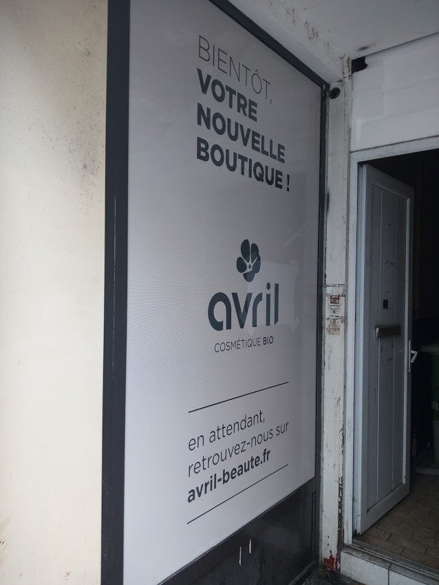 Habillage temporaire en microperforé d'un futur magasin de cosmétique Bio "Avril". Réalisé par Signarama Le Mans.