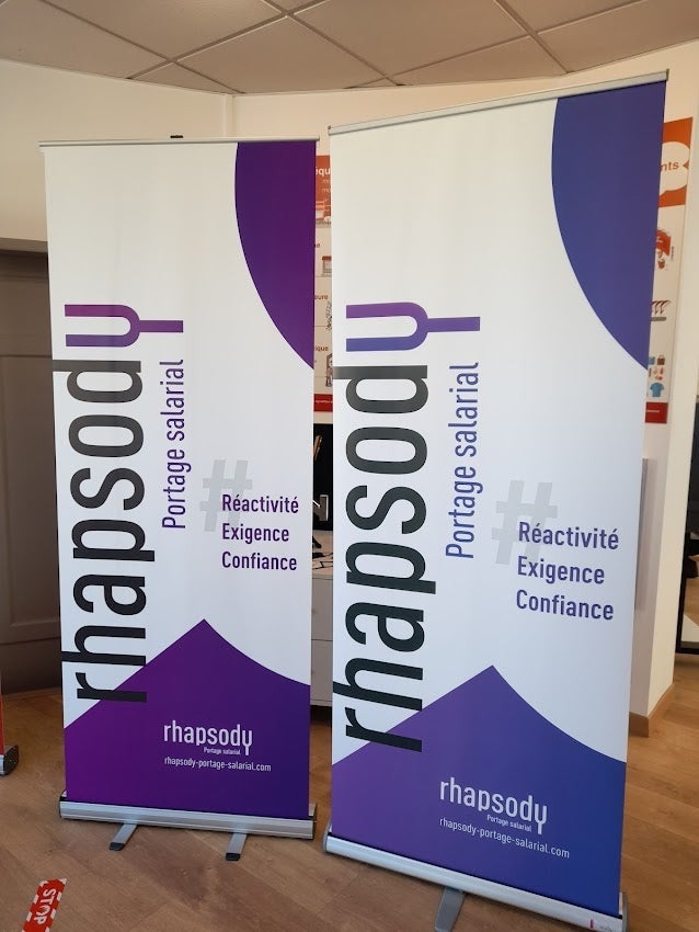 Réalisation d'un Mur d'images, d'un Comptoir d'Accueil et de Roll-Up pour Rhapsody par Signarama Le Mans