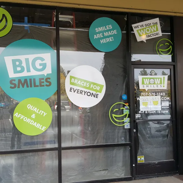Wow Smiles graphics and colorful circular decals across storefront windows