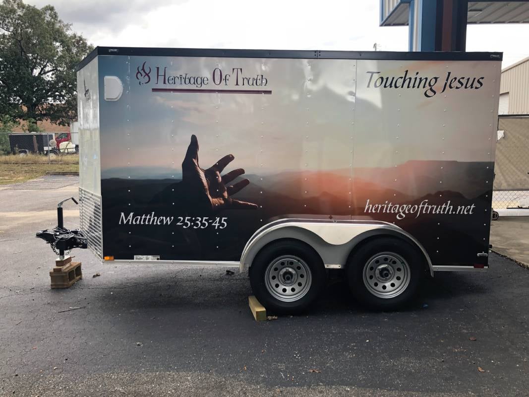 Professionally wrapped enclosed trailer with custom vinyl graphics for mobile business advertising.