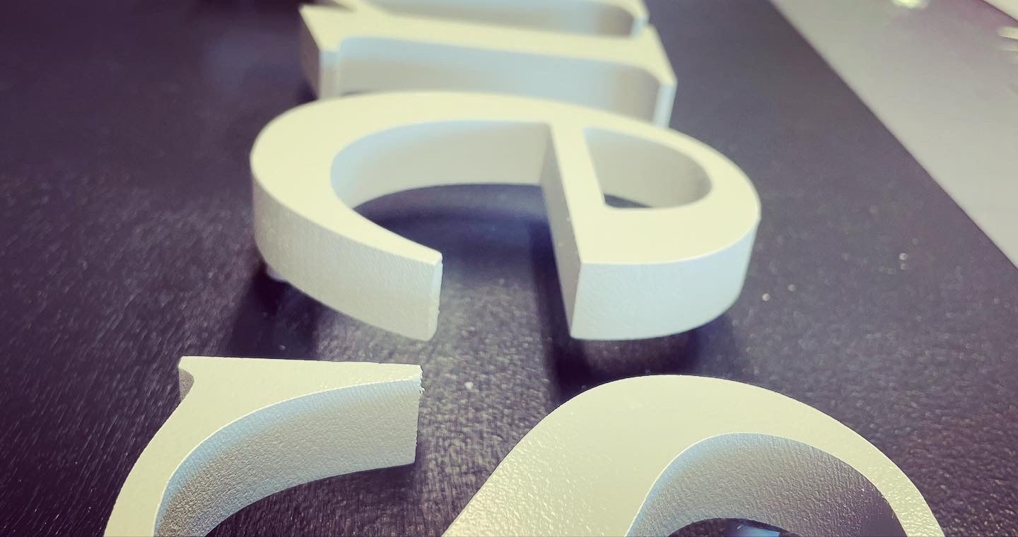 Fabrication d'une enseigne en lettre découpées relief + pose d'un éclairage rampe lumineuse en zone Bâtiments de France