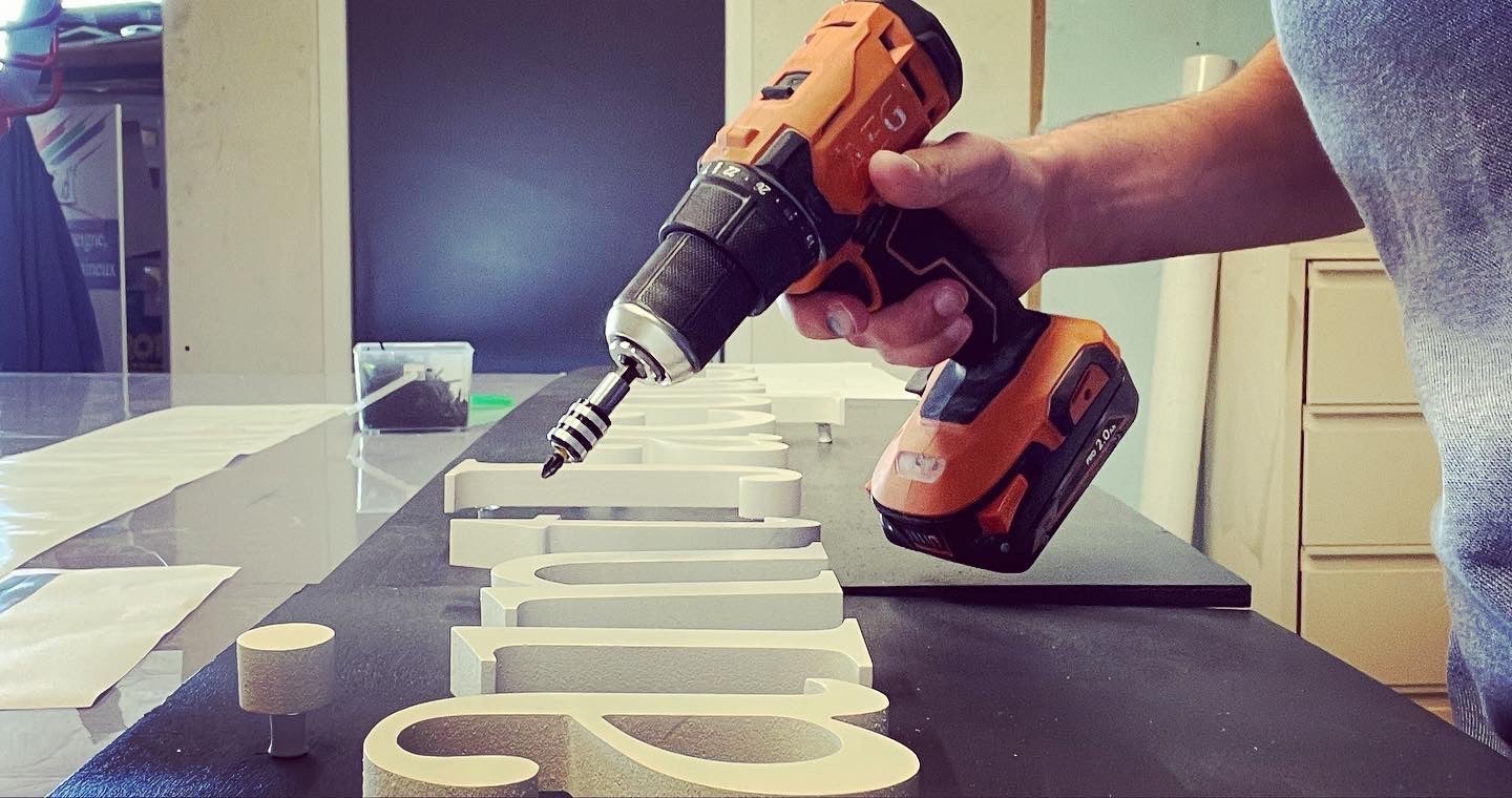 Fabrication d'une enseigne en lettre découpées relief + pose d'un éclairage rampe lumineuse en zone Bâtiments de France