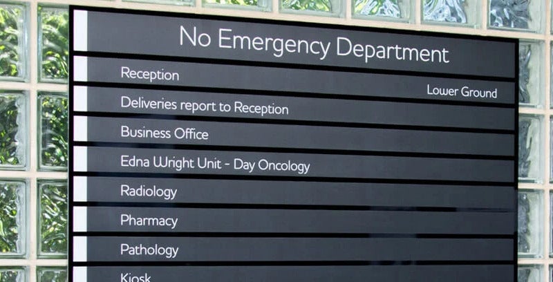 Hospital directory board with different departments. Black base with white writing