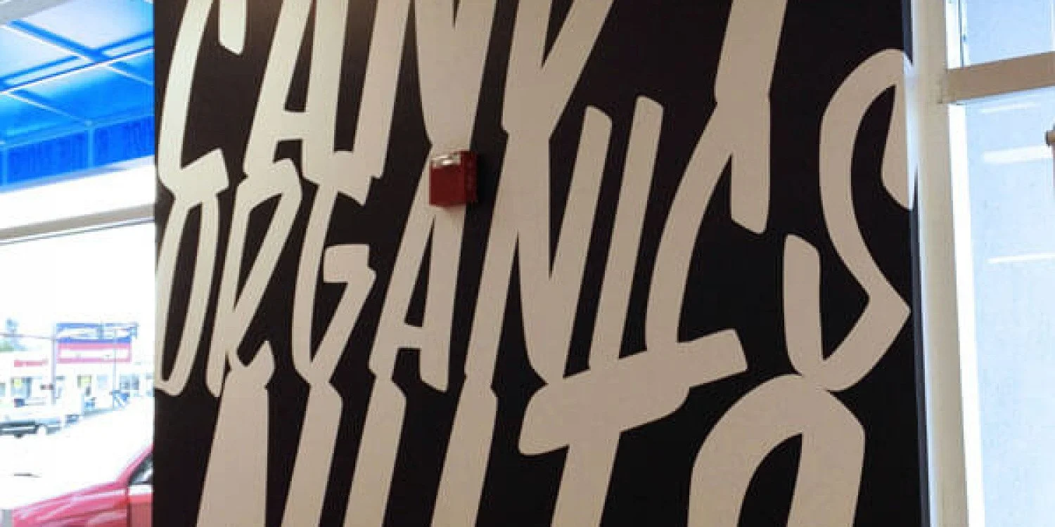 Sign writing on a store wall from the team at Signarama | White letters on a black wall