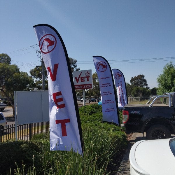 Teardrop Banners and Flags for vet along road in white and red