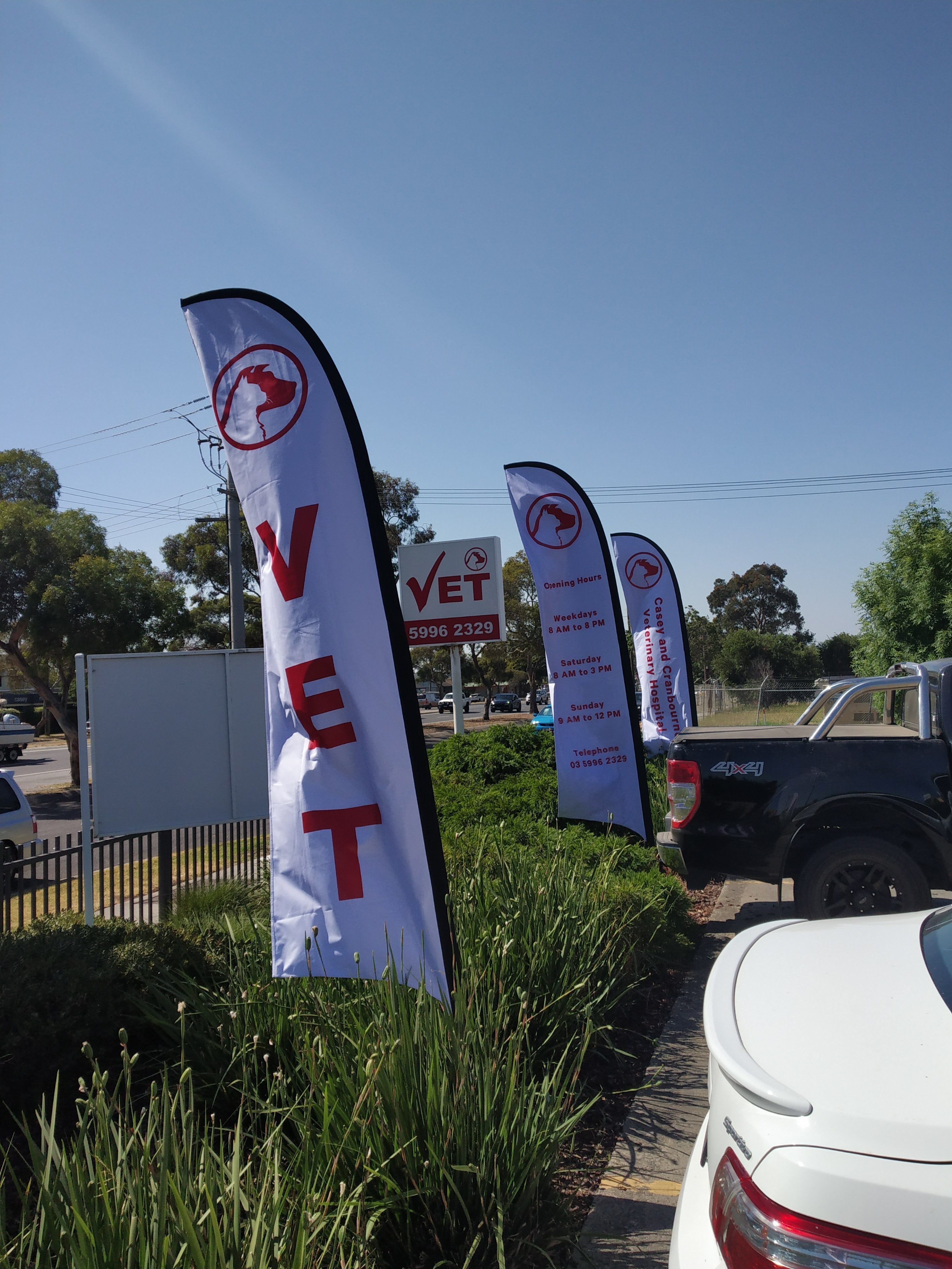 Teardrop Banners and Flags for vet along road in white and red