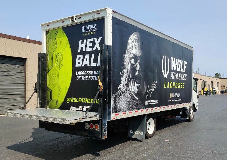 Custom truck wrap with full-color Wolf Athletics branding and vehicle graphics for mobile business advertising.