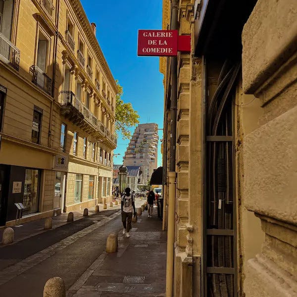 photo de la sortie de la galerie de la comedie a montpellier, en arriere plan ou voit une photo de l'architecture de montpellier